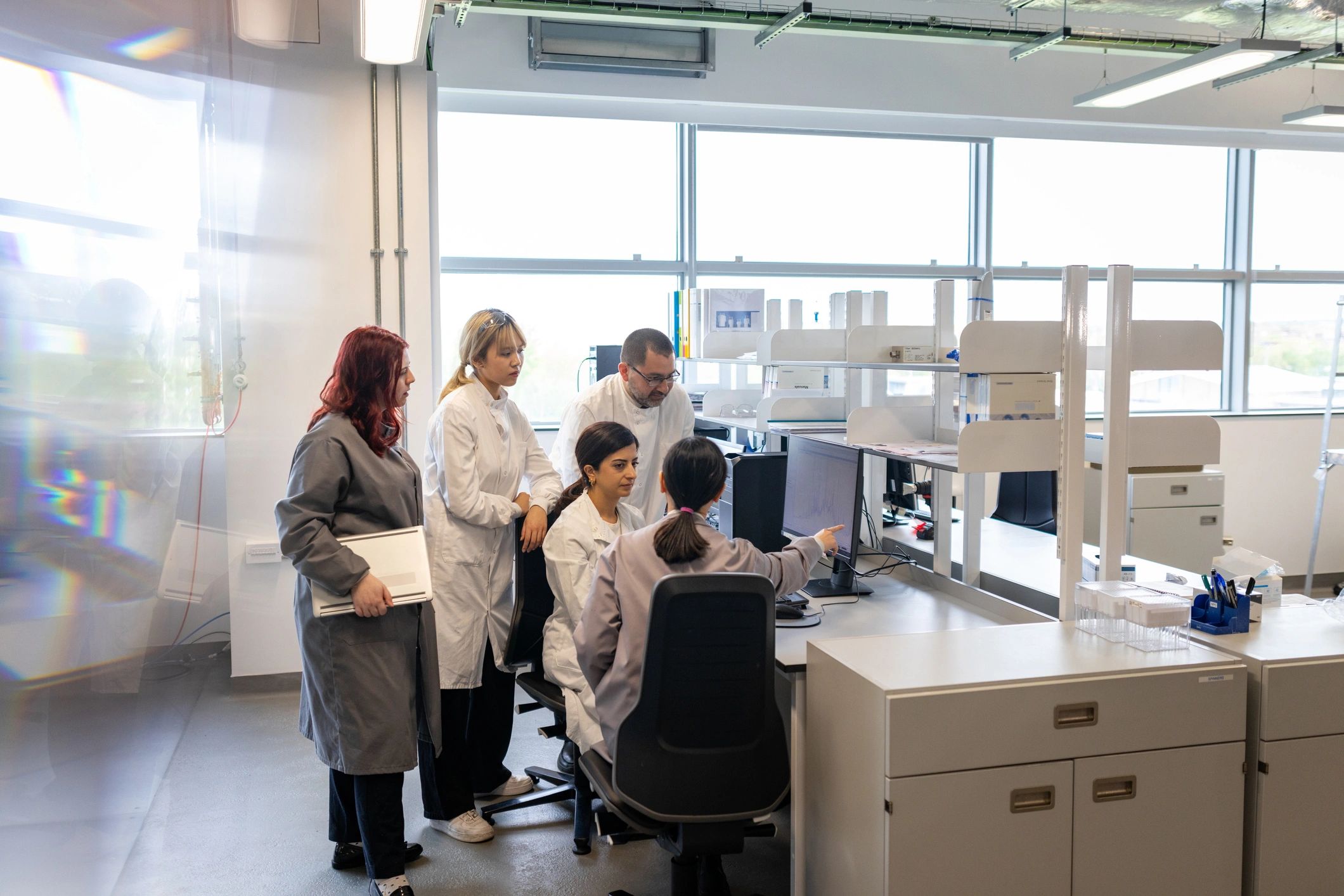 Scientific team gathered around a computer in a laboratory